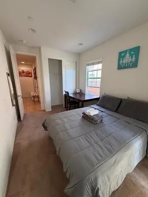a bedroom with a large bed and a table at Cozy 2-Bedroom Home in Eastvale in Corona