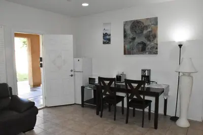 a living room with a dining room table and chairs at Cozy 2-Bedroom Home in Eastvale in Corona