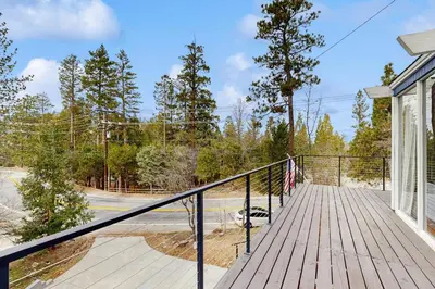 a house with a deck with a flag on it at Mountain Playhouse in Lake Arrowhead