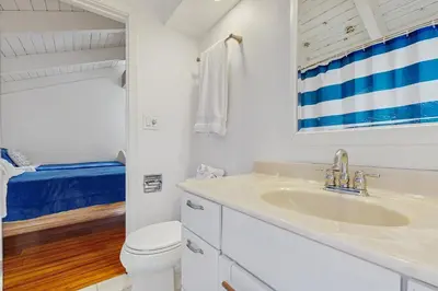 a white bathroom with a sink and a toilet at Mountain Playhouse in Lake Arrowhead