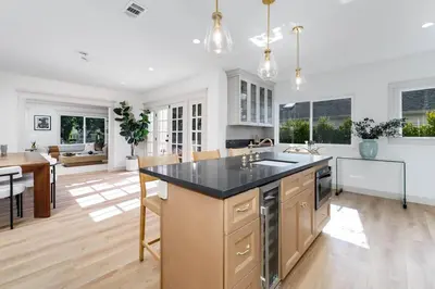 a kitchen with a large island with a black counter top at Chic WeHo Retreat near Sunset Blvd in Los Angeles