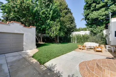 a backyard with a garage and a grass yard at Chic WeHo Retreat near Sunset Blvd in Los Angeles