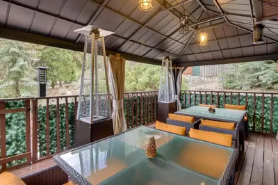 a deck with a table and chairs on a balcony at Outdoor Oasis in Pine Mountain Club! Cabin Getaway in Pine Mountain Club