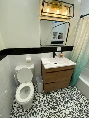 a bathroom with a toilet and a sink and a mirror at Cozy Studio by Rodeo Drive in Los Angeles