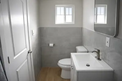 a bathroom with a toilet and a sink and a mirror at Carlton Motel in Los Angeles