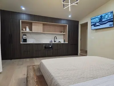 a bedroom with a large bed and a kitchen at Private Studio City Suite Walk to Universal-15 min in Los Angeles