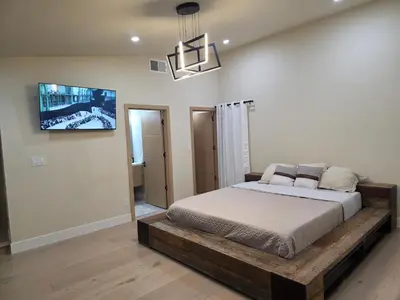a bedroom with a bed and a tv on the wall at Private Studio City Suite Walk to Universal-15 min in Los Angeles