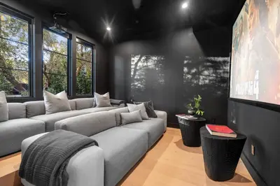a living room with couches and a flat screen tv at Colfax Estate in Los Angeles