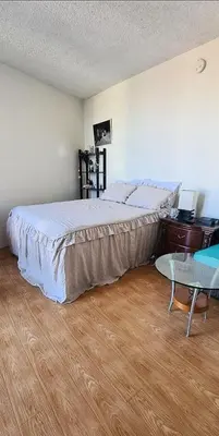 a bedroom with a large bed and a table at Fara UCLA in Los Angeles