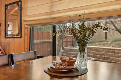 a table with a vase and some pastries on a plate at Pinecone Den in Big Bear Lake
