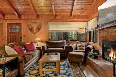 a living room with a couch and a fireplace at Pinecone Den in Big Bear Lake