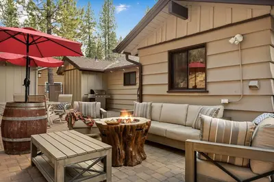 a patio with a couch and a table and an umbrella at Pinecone Den in Big Bear Lake