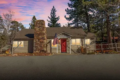 a house with a flag in front of it at Snuggle Down Cottage in Big Bear Lake