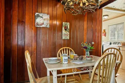 a dining room with a table and chairs at Snuggle Down Cottage in Big Bear Lake