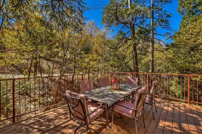 a table and chairs on a deck with a fence at Arrowhead Cabin Near Lake and Village in Lake Arrowhead