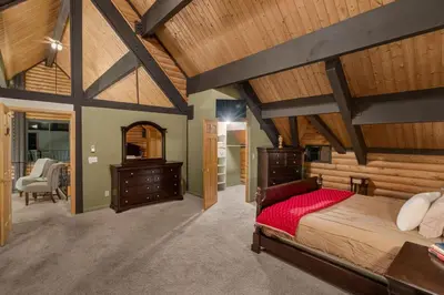 a bedroom with a large bed and wooden ceilings at Vista Lodge! 20 min to Silverwood Lake in Cedarpines Park