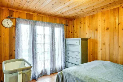 a bedroom with a bed and a window with a clock at Private Sauna and Mtn-View Deck! Kern County Home in Pine Mountain Club