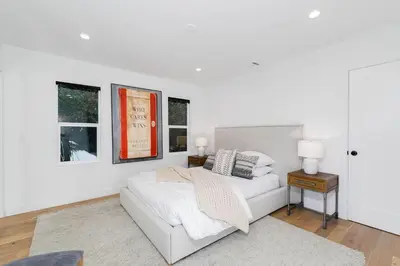 a white bedroom with a bed and two windows at Modern Mid-Wilshire Escape Prime Spot in Los Angeles
