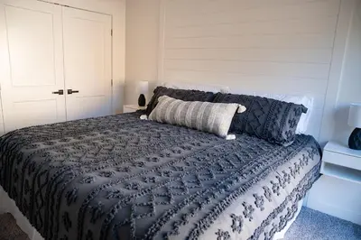 a bedroom with a bed with a blue comforter at Bearadise, LuxuryNew Build, Central, Hot Tub, EV ,Games in Big Bear Lake
