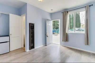 an empty living room with blue walls and a door at Cozy Studio, Studio City Unit 3 in Los Angeles