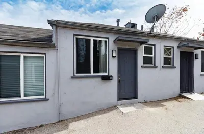a white house with a black door at Cozy Studio, Studio City Unit 3 in Los Angeles