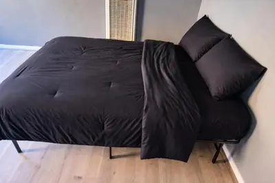 a black couch with two pillows on top of it at Hoover Homes for the Soul in Los Angeles