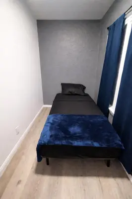 a bedroom with a bed with a blue blanket at Hoover Homes for the Soul in Los Angeles