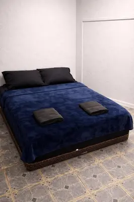 a bed with blue sheets and two pillows on it at Hoover Homes for the Soul in Los Angeles