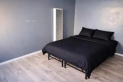 a bedroom with a bed with black pillows on it at Hoover Homes for the Soul in Los Angeles