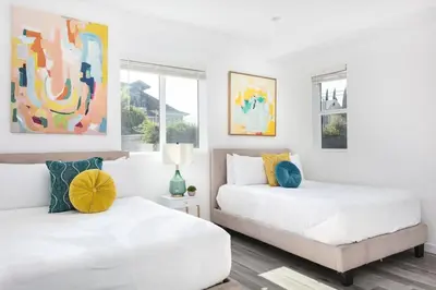 two beds in a bedroom with white walls at Central LA Escape Near Universal & Beaches in Los Angeles