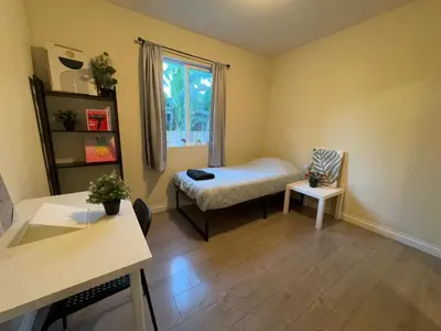 a small room with a bed and a window at Blue Urban Stay LA in Los Angeles
