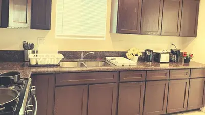 a kitchen with wooden cabinets and a sink at Blue Urban Stay LA in Los Angeles
