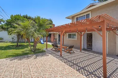 a patio with a wooden pergola and a bench at Spacious 5 Bedroom Home Near Disneyland & Knotts with Jacuzzi Spa in Norwalk