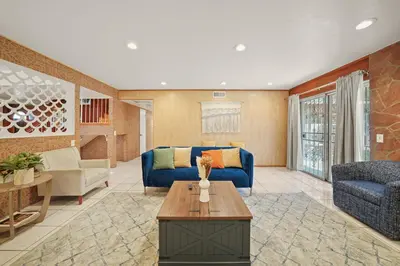 a living room with a blue couch and a table at Spacious 5 Bedroom Home Near Disneyland & Knotts with Jacuzzi Spa in Norwalk