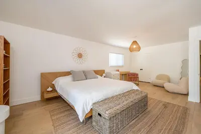 a white bedroom with a bed and a chair at Newly remodeled home w pool & private back yard in Thousand Oaks