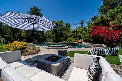 a patio with a fire pit and an umbrella at Newly remodeled home w pool & private back yard in Thousand Oaks