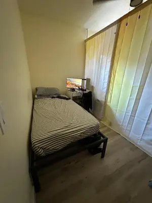 a bedroom with a bed and a desk with a laptop at Shared room, Prime Location LA in Los Angeles