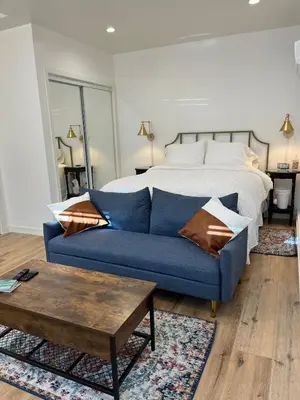 a living room with a bed and a blue couch at The Sycamore Suite in Santa Clarita