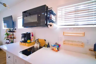a kitchen with a white counter top with a microwave at The Sycamore Suite in Santa Clarita