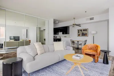 a living room with a white couch and a table at Blueground Hollywood gym AC nr Runyon LAX-1344 in Los Angeles