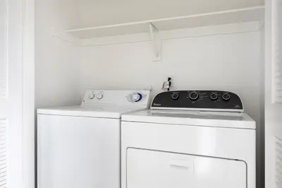 a washer and dryer in a laundry room with a shelf at Blueground Playa del Rey pool nr Dockweiler LAX-1431 in Los Angeles