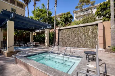 a pool with a table and a chair next to a building at Blueground Playa del Rey pool nr Dockweiler LAX-1431 in Los Angeles