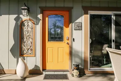 a yellow front door of a house with a teddy bear at Peaceful Mountain Sanctuary near Arrowhead Village in Lake Arrowhead