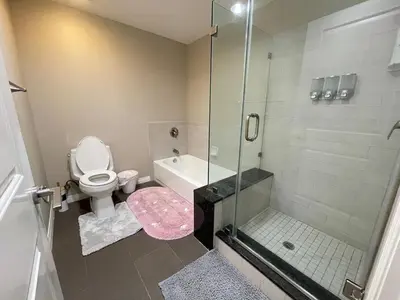 a bathroom with a toilet and a glass shower at Spacious 2 Bed, 2-Bath Apartment in Monterey Park in Monterey Park