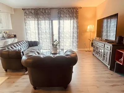 a living room with a leather couch and a table at Spacious 2 Bed, 2-Bath Apartment in Monterey Park in Monterey Park