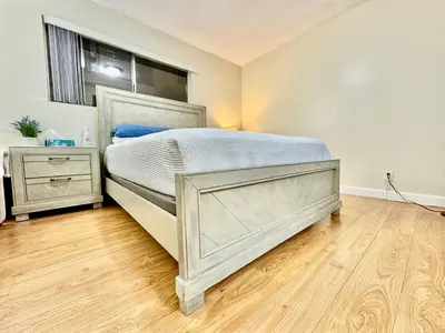 a bedroom with a large bed and a wooden floor at Proper Stays at Melrose - West Hollywood Premium R suite in Los Angeles