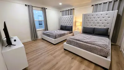 a bedroom with two beds and a flat screen tv at Renovated Three Bedroom Near Cedars Sinai and Beverly Hills With Parking in Los Angeles