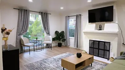 a living room with a fireplace with a tv above it at Renovated Three Bedroom Near Cedars Sinai and Beverly Hills With Parking in Los Angeles