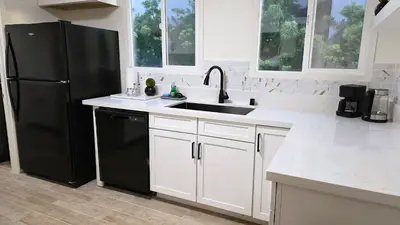a kitchen with a black refrigerator and a sink at Renovated Three Bedroom Near Cedars Sinai and Beverly Hills With Parking in Los Angeles