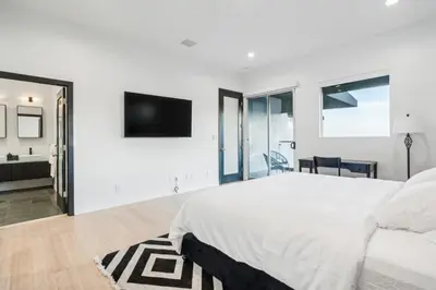 a white bedroom with a large bed and a television at Hollywood Hills Luxury Nest Views Pool Spa in Los Angeles